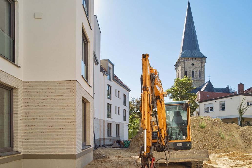 Ein Bagger im Sonnenschein, hinter dem "L".