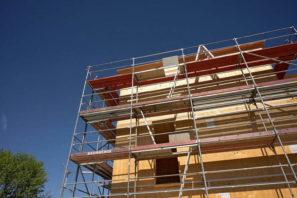 Der Rohbau eines Hauses mit Gerüst vor blauem Himmel